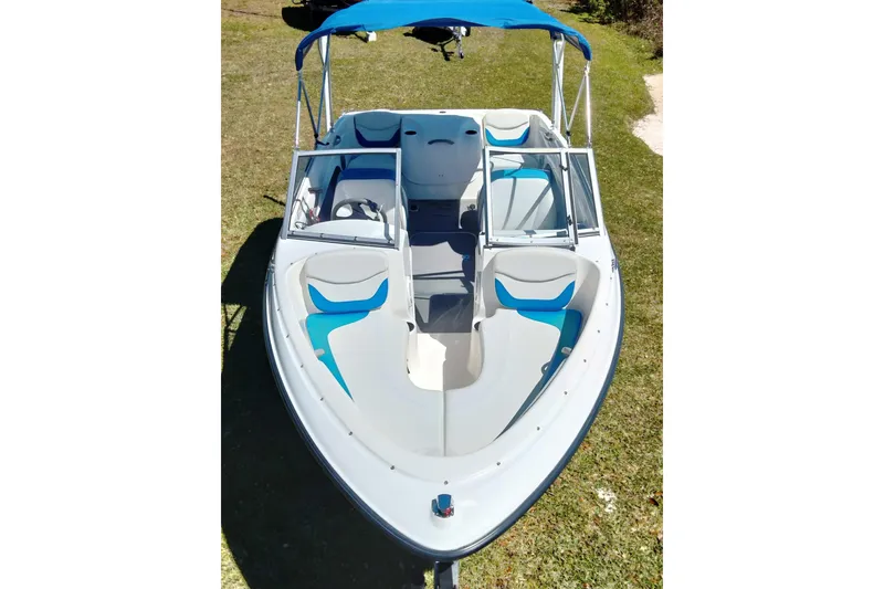 The Image of 2007 Bayliner 175 Bowrider with blue canopy, viewed from above on grass. - 1