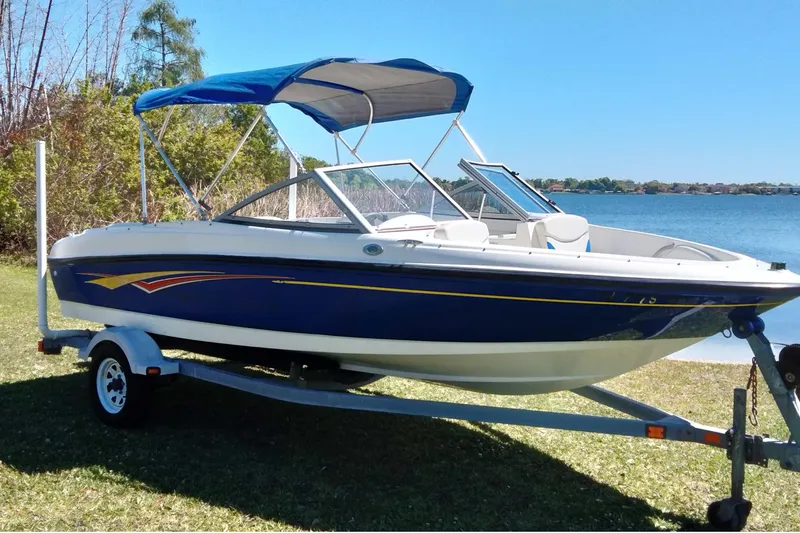 Slide: The Image of 2007 Bayliner 175 Bowrider boat on trailer by a lake under clear blue sky. - 3