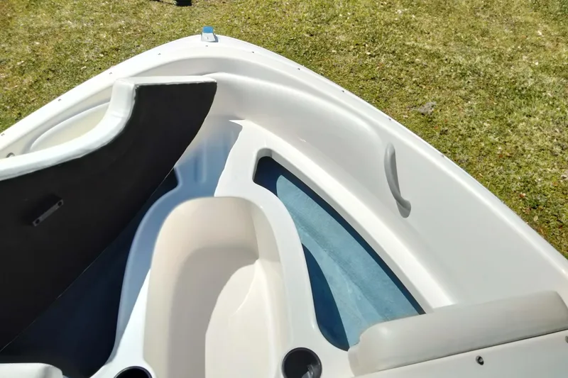 Slide: The Image of 2007 Bayliner 175 Bowrider interior with seating and cup holders on grassy background. - 8
