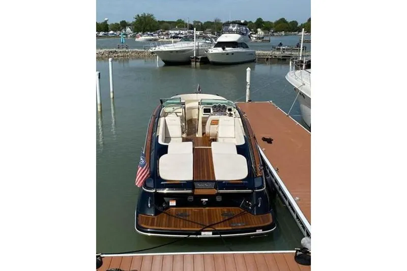 Slide: The Image of 2018 Chris-Craft Launch 34 docked at marina, showcasing elegant design and spacious seating. - 10