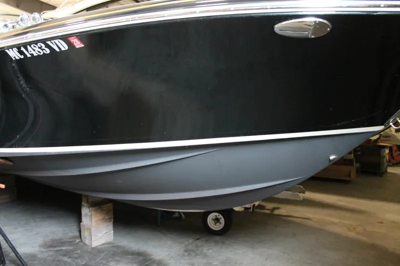 Slide: The Image of 2018 Chris-Craft Launch 34 boat hull in storage, showcasing sleek black design. - 11