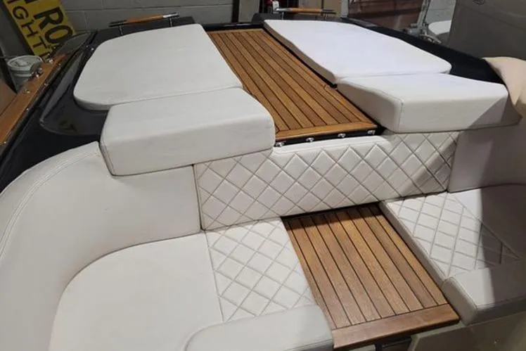 Slide: The Image of 2018 Chris-Craft Launch 34 boat interior with white quilted seating and wooden deck. - 15