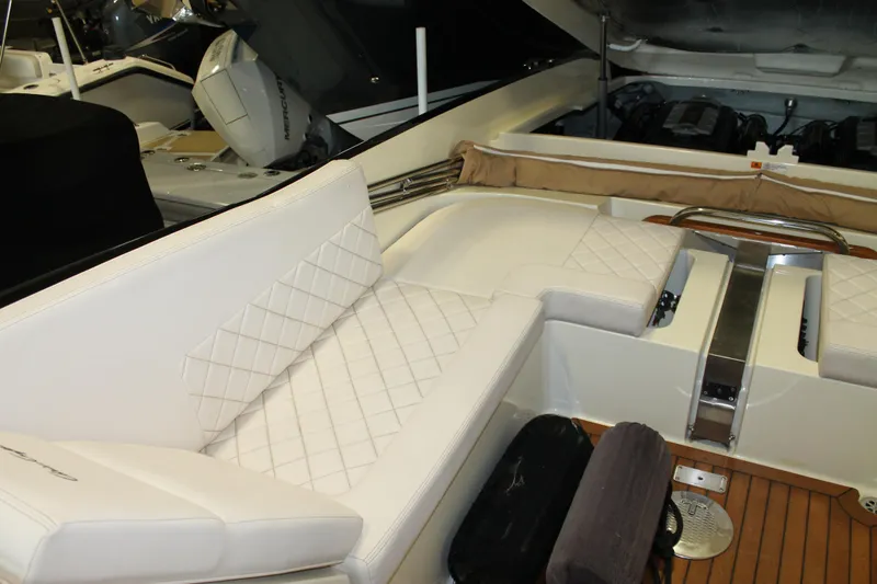 Slide: The Image of 2018 Chris-Craft Launch 34 interior with white quilted seating and wooden flooring. - 17