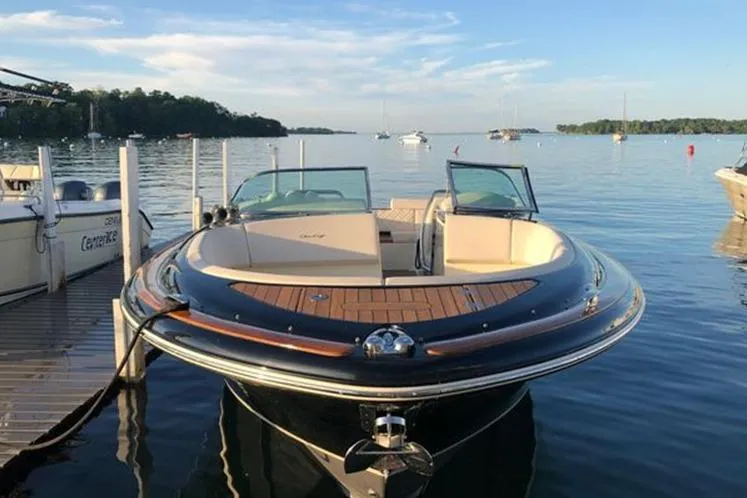 Slide: The Image of 2018 Chris-Craft Launch 34 boat docked on a serene lake. - 2
