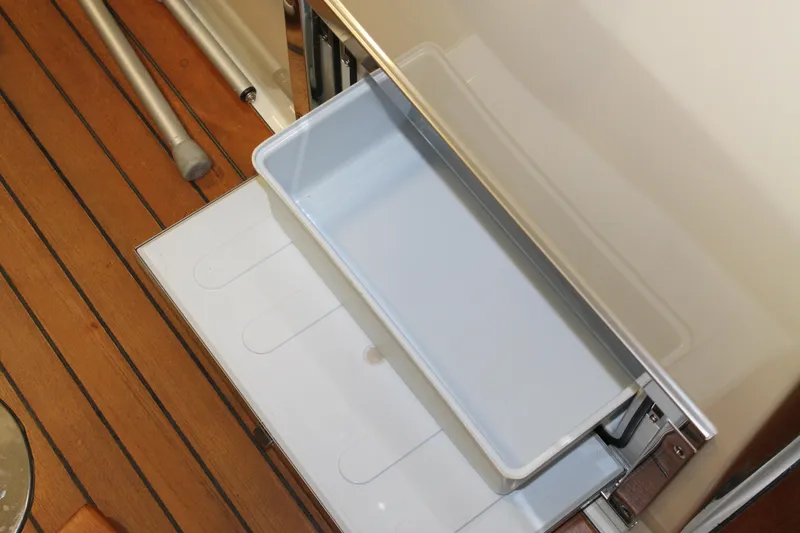 Slide: The Image of 2018 Chris-Craft Launch 34 boat interior with open storage compartment on wooden deck. - 22