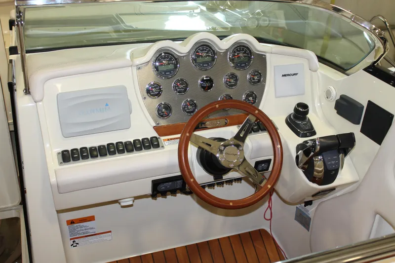 Slide: The Image of 2018 Chris-Craft Launch 34 dashboard with wooden steering wheel and modern controls. - 25