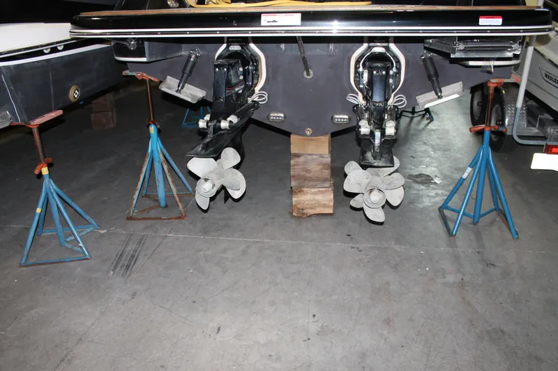 Slide: The Image of 2018 Chris-Craft Launch 34 boat on stands, showing dual propellers in a garage. - 55