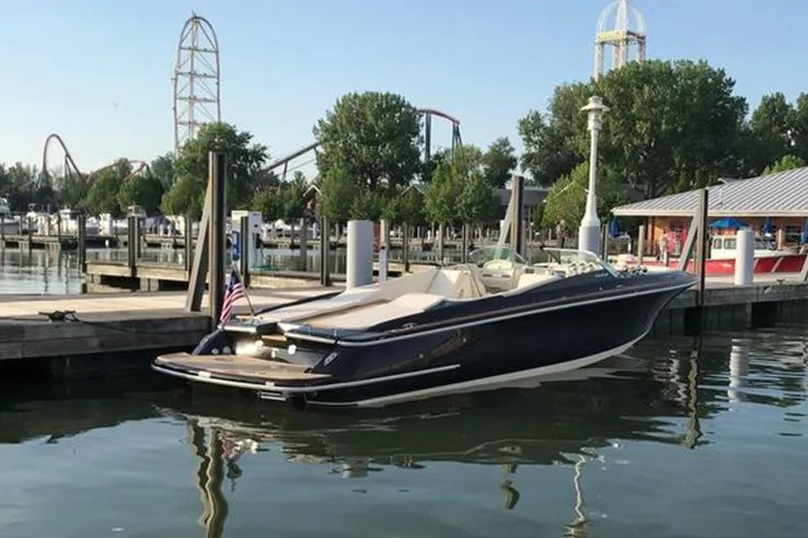 Slide: The Image of 2018 Chris-Craft Launch 34 boat docked at marina with amusement park in background. - 7