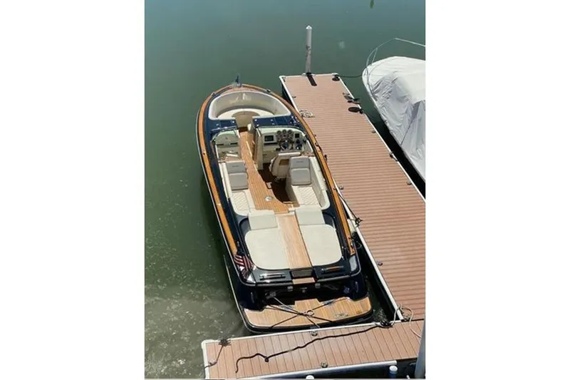 Slide: The Image of 2018 Chris-Craft Launch 34 boat docked, featuring elegant wood and leather interior. - 9