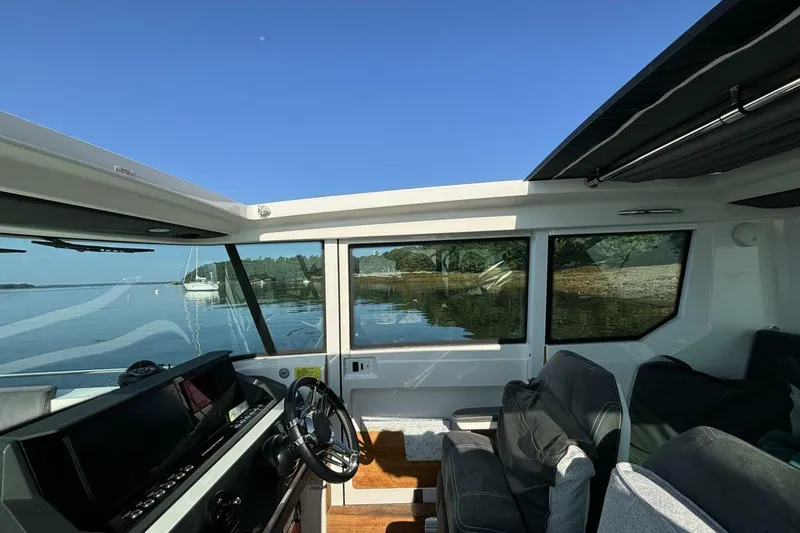 Slide: The Image of Interior view of 2019 Axopar 28 Cabin boat with scenic water backdrop. - 11