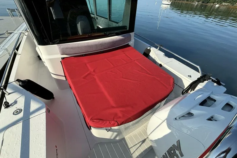 Slide: The Image of 2019 Axopar 28 Cabin boat with red sunbed cover on deck. - 19