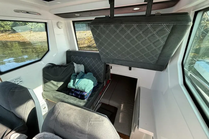 Slide: The Image of Interior of 2019 Axopar 28 Cabin boat with seating and windows. - 2