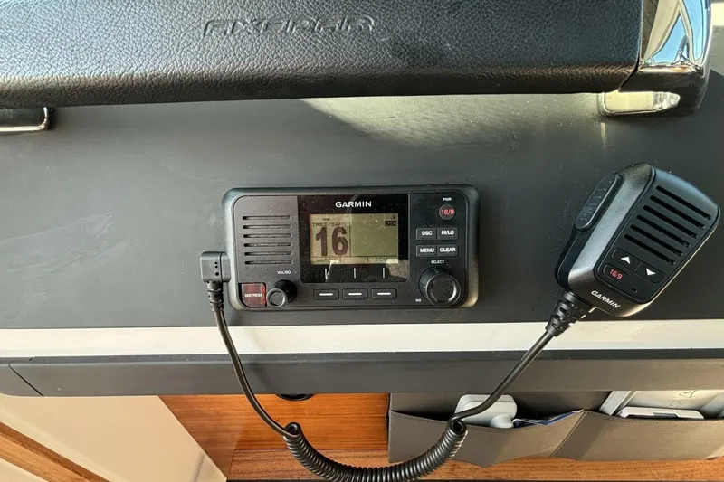 Slide: The Image of Garmin marine radio on 2019 Axopar 28 Cabin dashboard, featuring channel display and microphone. - 24