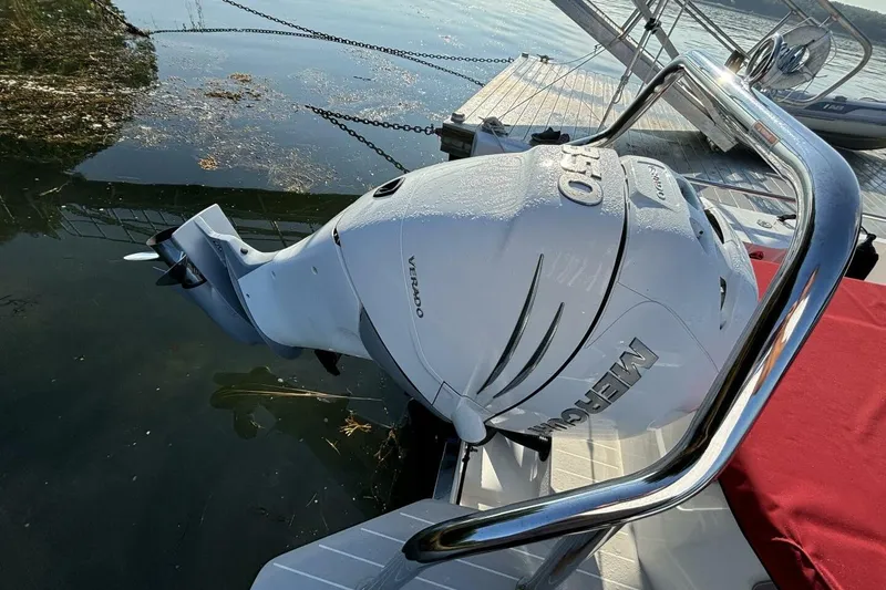 Slide: The Image of Outboard motor on 2019 Axopar 28 Cabin boat, docked by the water. - 29