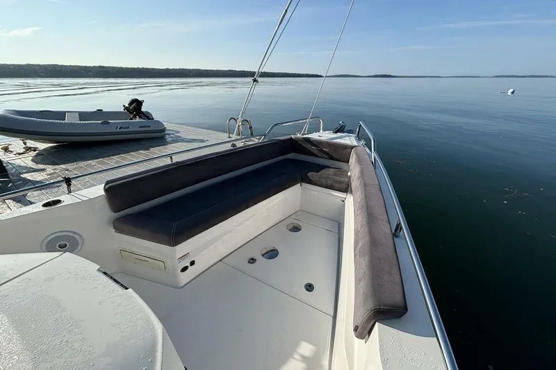 Slide: The Image of 2019 Axopar 28 Cabin boat with seating, docked on calm water. - 3