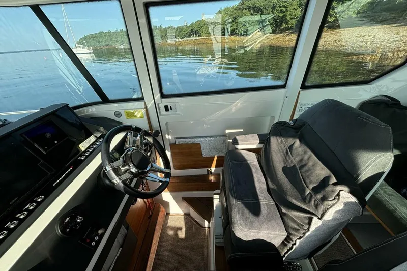 Slide: The Image of Interior of 2019 Axopar 28 Cabin boat with steering wheel and seating. - 7