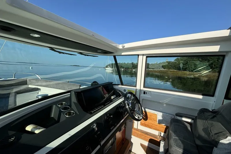 Slide: The Image of Interior view of 2019 Axopar 28 Cabin boat with scenic water and shoreline. - 8