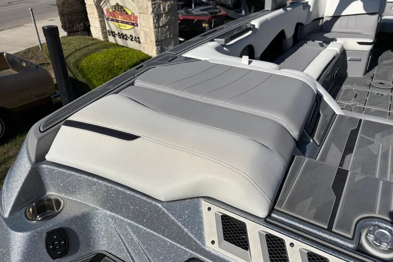 Slide: The Image of 2021 Supra SE 550 boat interior with gray and white seating, outdoor setting. - 11