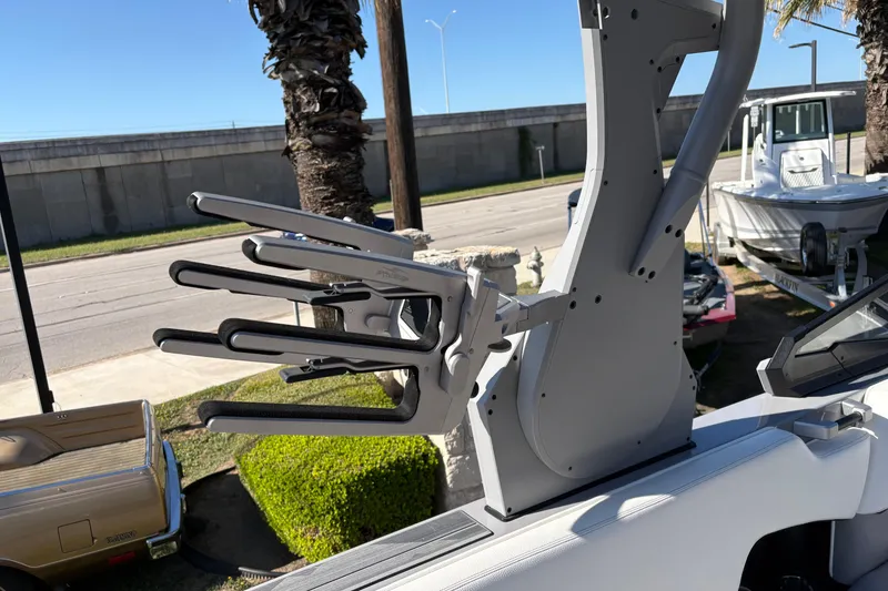 Slide: The Image of 2021 Supra SE 550 boat with wakeboard rack, parked near palm trees. - 20