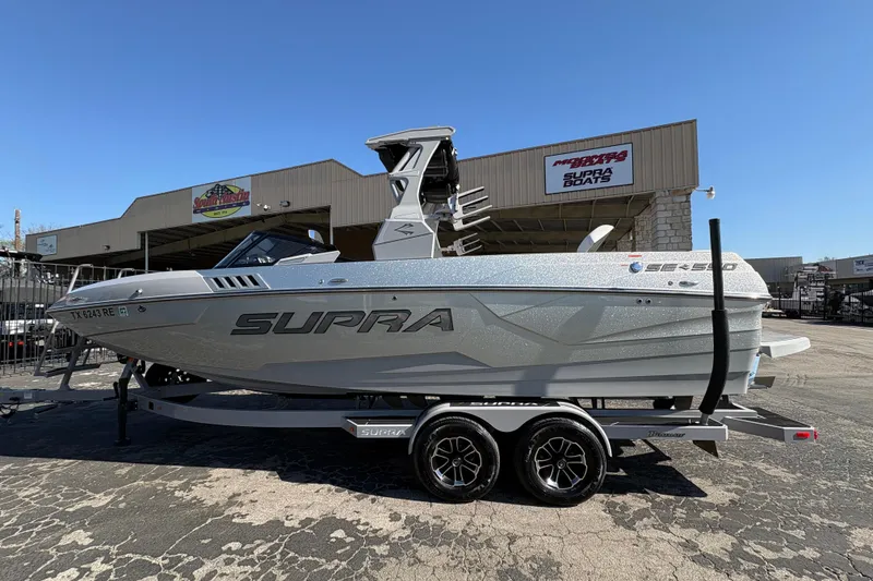 Slide: The Image of 2021 Supra SE 550 boat on trailer at dealership, showcasing sleek design and branding. - 5