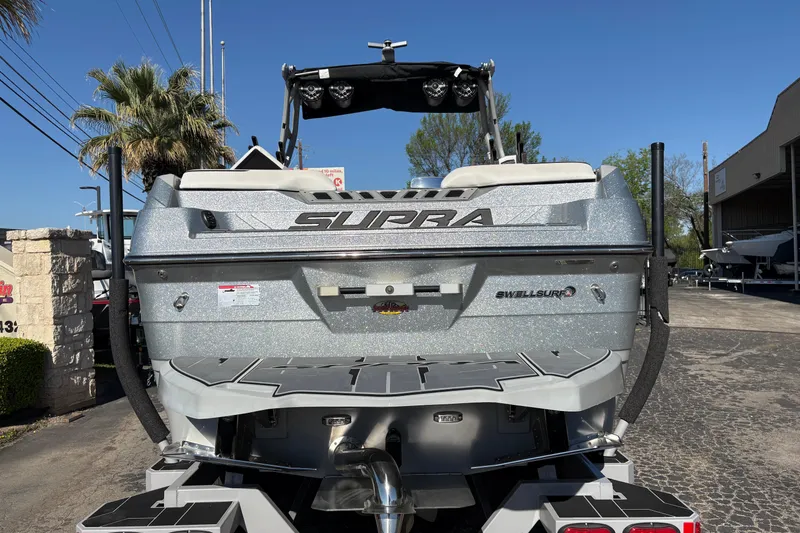 Slide: The Image of 2021 Supra SE 550 boat rear view with SwellSurf technology, parked outdoors. - 7