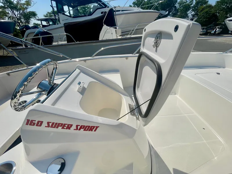 Slide: The Image of The image shows the cockpit of a Boston Whaler 160 Super Sport with open storage. - 8