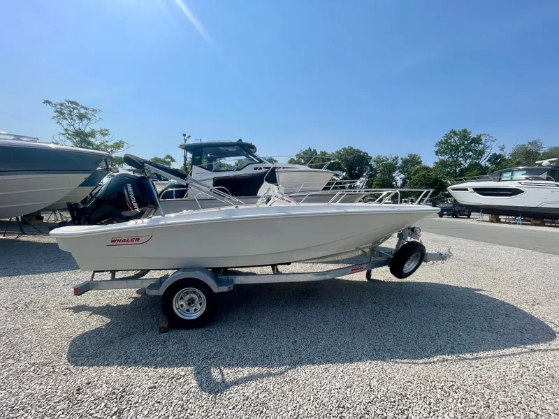 Slide: The Image of Boston Whaler 160 Super Sport 2026 on a trailer, surrounded by other boats outdoors. - 0