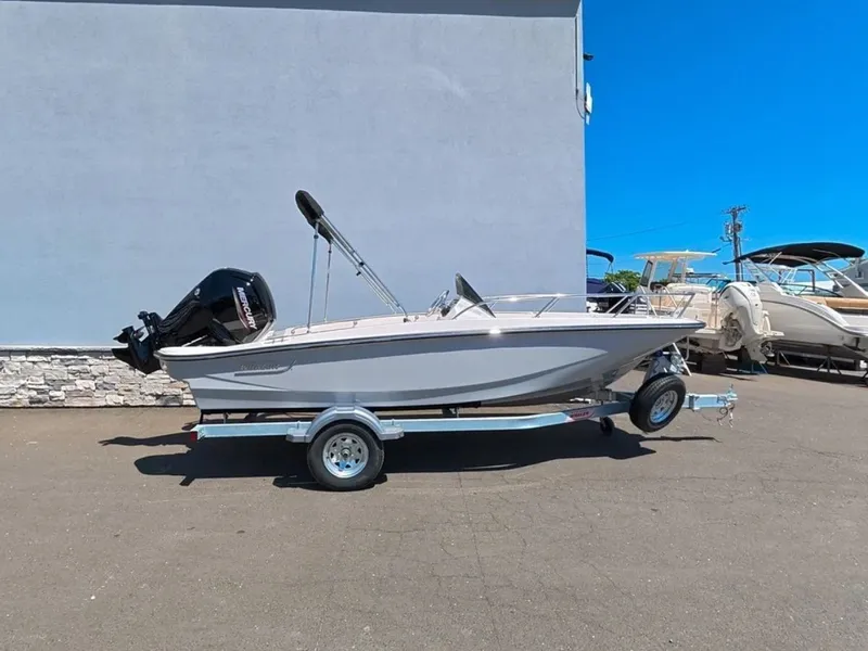 Slide: The Image of A 2026 Boston Whaler 160 Super Sport on a trailer in front of a gray building. - 0