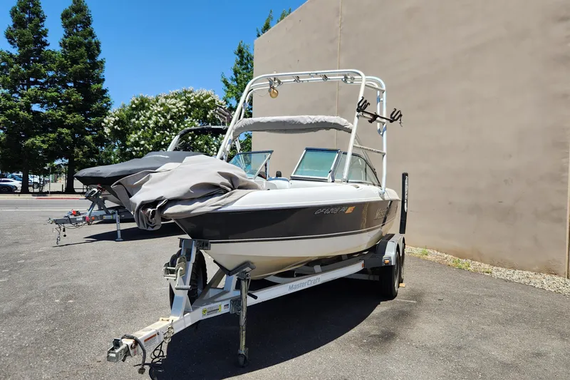 Slide: The Image of 2000 MasterCraft Prostar 205 boat on trailer, parked outdoors. - 2