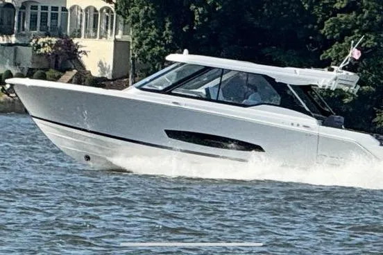 The Image of Modern 2025 Regal LX43 boat cruising on a scenic waterway. - 0