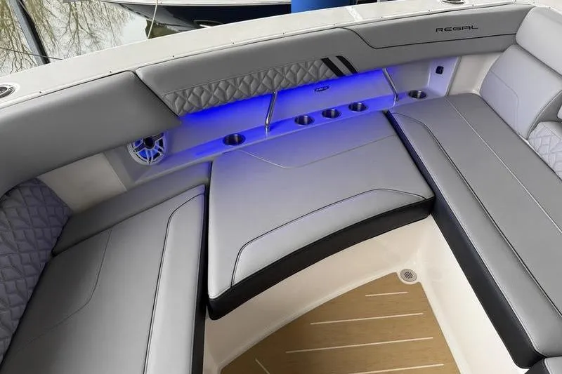 Slide: The Image of Luxurious seating area on 2025 Regal LX43 boat with blue LED lighting. - 23