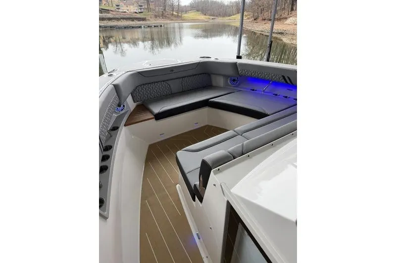 Slide: The Image of Luxurious 2025 Regal LX43 boat interior with sleek seating and ambient lighting by a serene lake. - 25