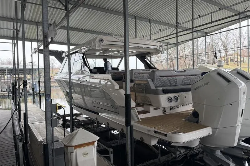 Slide: The Image of 2025 Regal LX43 boat docked in covered marina with Mercury engines. - 3