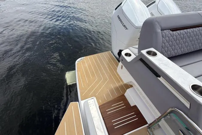 Slide: The Image of 2025 Regal LX43 boat with Mercury engines, featuring elegant seating and teak deck on water. - 31
