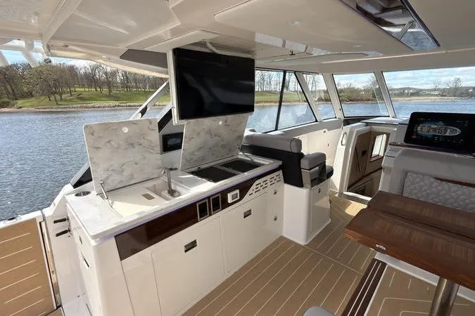 Slide: The Image of Luxurious 2025 Regal LX43 yacht interior with modern kitchen and scenic water view. - 34