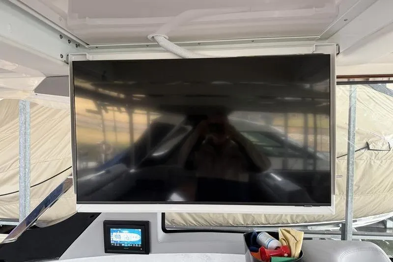 Slide: The Image of Flat-screen TV and control panel on 2025 Regal LX43 boat interior. - 35