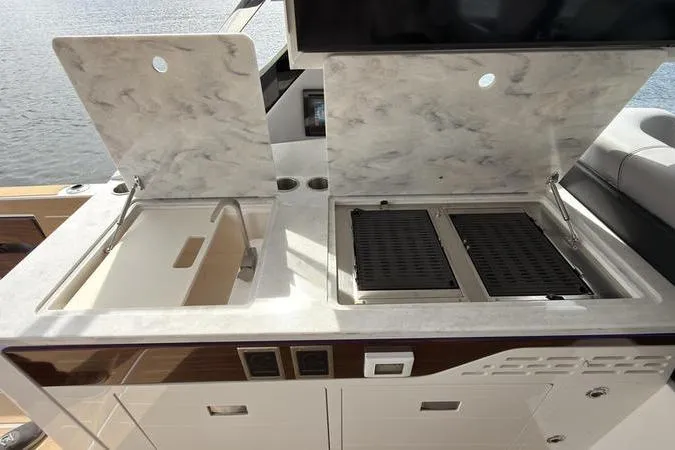 Slide: The Image of Outdoor kitchen on a 2025 Regal LX43 boat with sink and grill. - 36