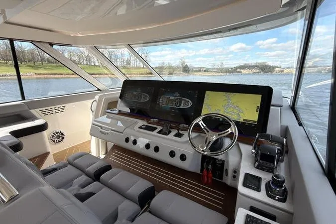 Slide: The Image of Luxurious 2025 Regal LX43 yacht cockpit with advanced navigation system and scenic water view. - 47