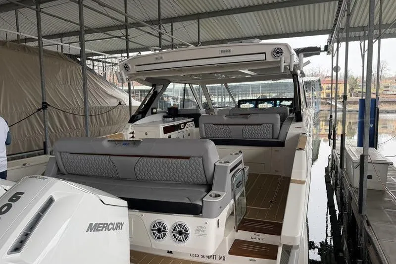 Slide: The Image of 2025 Regal LX43 boat with Mercury engine docked under a covered marina. - 5