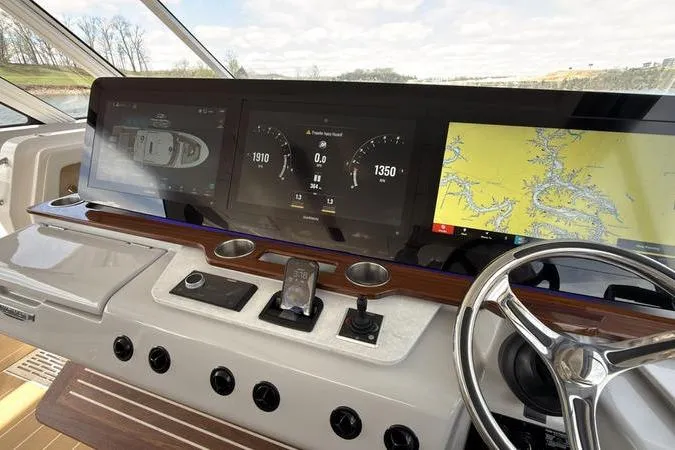 Slide: The Image of Dashboard of 2025 Regal LX43 boat with navigation screens and steering wheel. - 53
