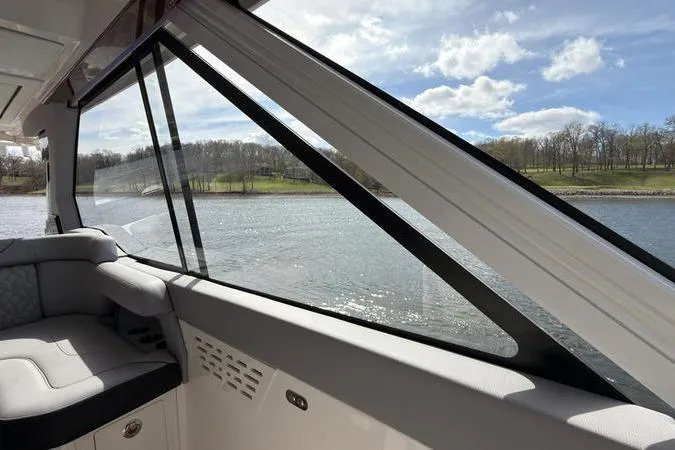 Slide: The Image of Interior view of 2025 Regal LX43 yacht, showcasing sleek design and scenic waterway. - 57