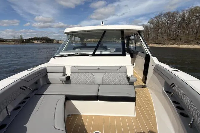Slide: The Image of 2025 Regal LX43 boat interior with sleek seating and modern design on a sunny day. - 61