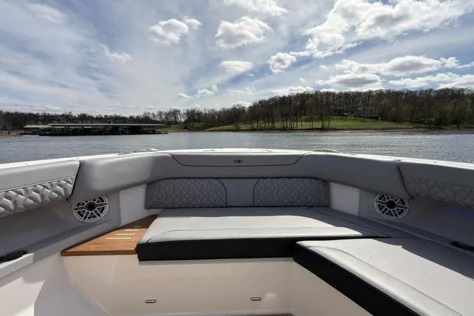 Slide: The Image of Luxurious 2025 Regal LX43 boat interior with plush seating, overlooking serene lake and cloudy sky. - 64