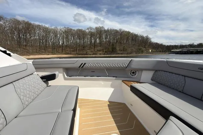 Slide: The Image of Luxurious 2025 Regal LX43 boat interior with gray seating and scenic lake view. - 65