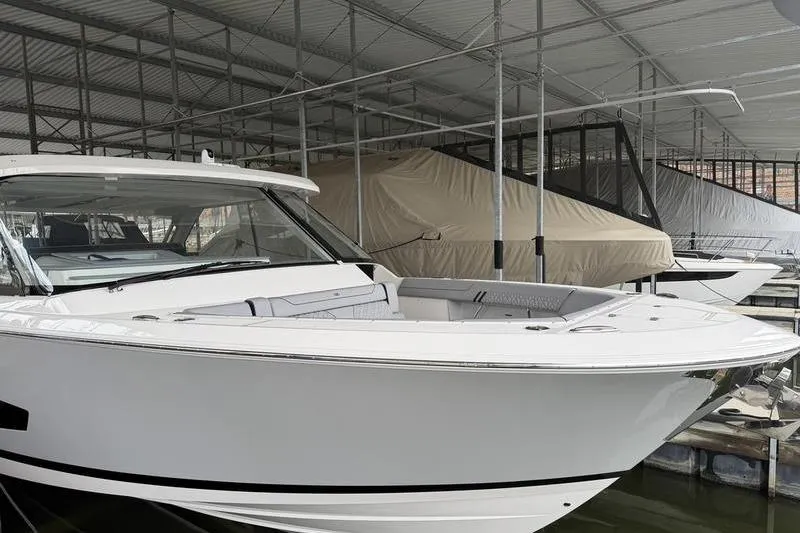Slide: The Image of 2025 Regal LX43 boat docked in covered marina, showcasing sleek design. - 7