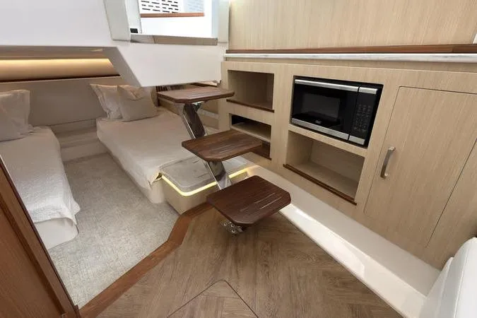 Slide: The Image of Luxurious 2025 Regal LX43 yacht interior with twin beds, wooden steps, and built-in microwave. - 81