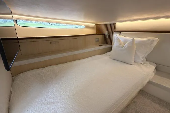 Slide: The Image of Luxurious cabin interior of 2025 Regal LX43 yacht with modern bedding and ambient lighting. - 84