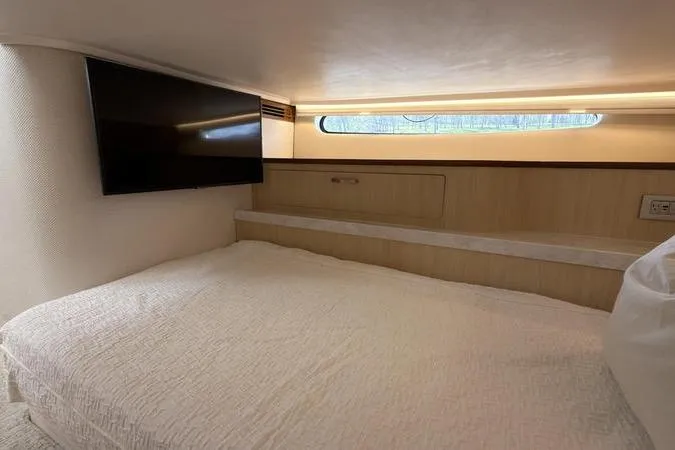 Slide: The Image of Cozy cabin interior of 2025 Regal LX43 yacht with bed and wall-mounted TV. - 86