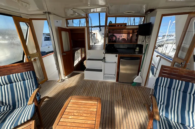 Slide: The Image of 1987 Lien Hwa 47 Cockpit Motoryacht interior with wooden deck and striped seating. - 23