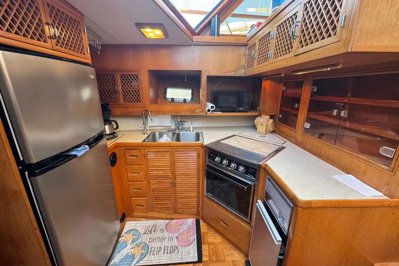 Slide: The Image of 1987 Lien Hwa 47 Cockpit Motoryacht kitchen with wood cabinetry and modern appliances. - 9